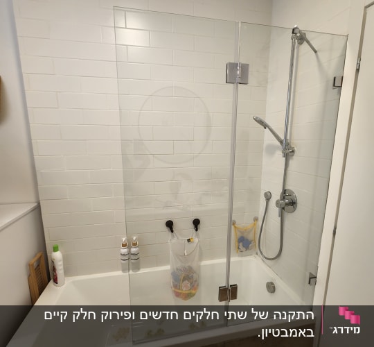 אמבטיה עם דלת זכוכית, ראש מקלחת ומוצרי טיפוח